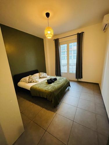 une chambre avec un lit et une grande fenêtre dans l'établissement Appartement Californie Beach, à Nice