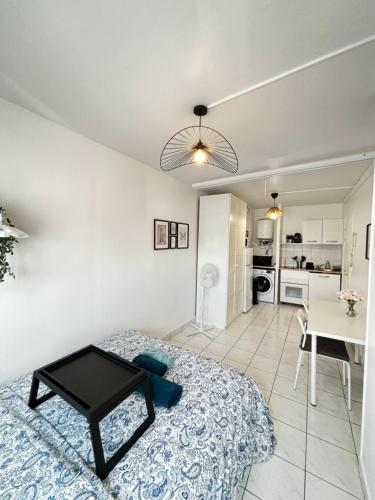 une chambre avec un lit et une table et une cuisine dans l'établissement Studio, projecteur & métro 100m, à Saint-Ouen