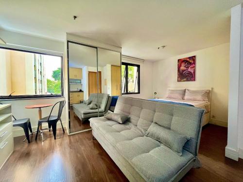 a living room with a couch and a bed at LFlats Hotel Alameda Lorena Jardins in Sao Paulo