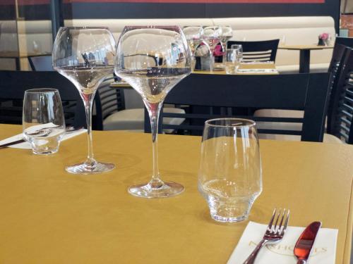 four glasses of wine sitting on a table at Nash Suites Airport Hotel in Geneva