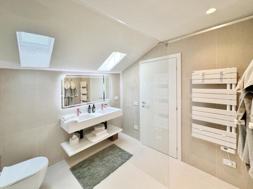 a bathroom with a white toilet and a sink at B&B Carmen Garden in Burano