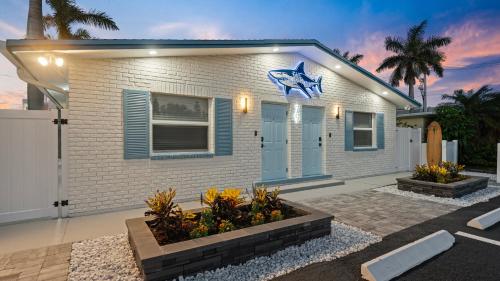 a small white house with a blue star on it at The Shark Tank Cocoa Beach - 2 2BR Units - 4BR Total - Each Unit Sleeps 5 - Walk to Downtown & Beach in Cocoa Beach