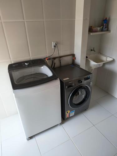 a kitchen with a washing machine and a sink at Acomodação Cambirela in Palhoça