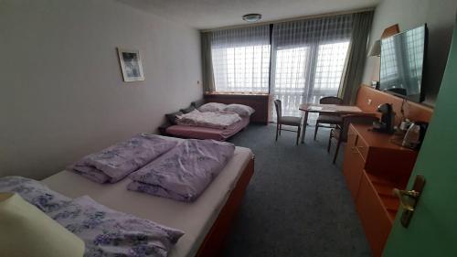 a bedroom with two beds and a table and a desk at Apartmán Almberg - Mitterdorf - Mitterfirmiansrout in Philippsreut