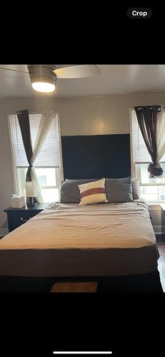 a bedroom with a large bed with two windows at BVF2Bedroom in Harrisburg