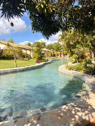 a pool of water in a park with trees at La Belle Resort Lago Azul in Nísia Floresta
