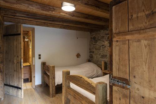 - une chambre avec 2 lits dans une pièce dotée de murs en bois dans l'établissement Bois Neige, à La Chapelle-dʼAbondance