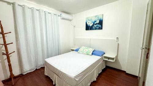 a small white room with a bed and a window at 200 metros da Praia Central na Avenida Brasil próximo à Roda Gigante e Shopping Atlântico in Balneário Camboriú