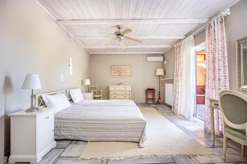 a bedroom with a bed and a ceiling fan at Corinthian Blue Retreat in Katakoúli