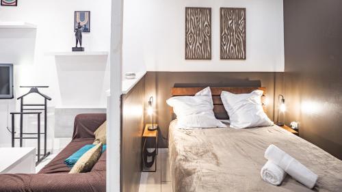 une chambre avec un lit avec des oreillers blancs dans l'établissement Smart Confort 8 - Studio confort et stylé, à Troyes