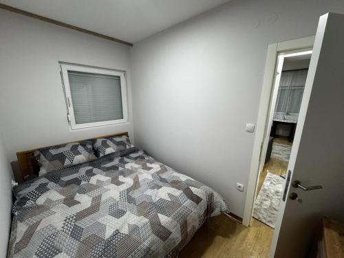 una camera da letto con un letto e una finestra di Apartment Amistad Novi Sad a Novi Sad