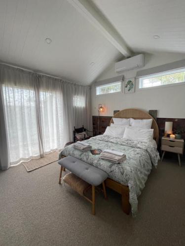 a bedroom with a large bed and two windows at The Shack in Christchurch