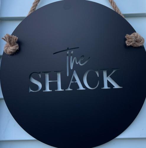 a sign that reads the shack hanging on a building at The Shack in Christchurch
