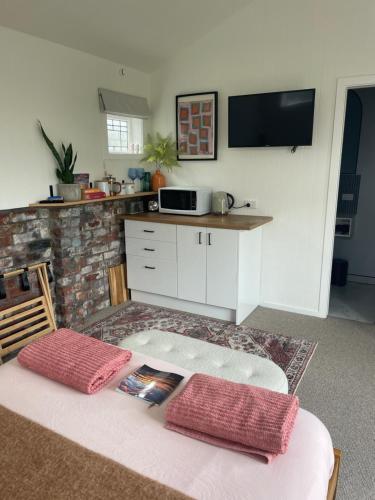 a kitchen with a table and a counter with a microwave at The Shack in Christchurch