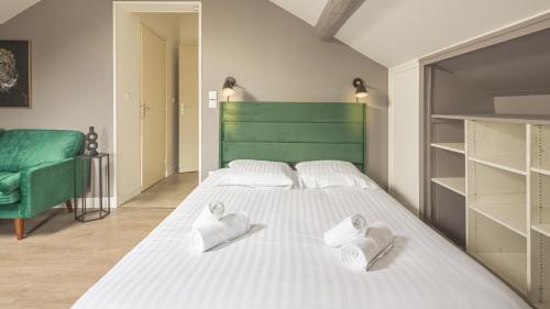 une chambre avec un grand lit blanc avec deux serviettes dans l'établissement Cœur d'Amazonie - Neuf et rénové, à Châlons-en-Champagne