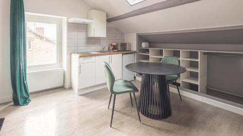 une cuisine avec une table, deux chaises et une table dans l'établissement Cœur d'Amazonie - Neuf et rénové, à Châlons-en-Champagne