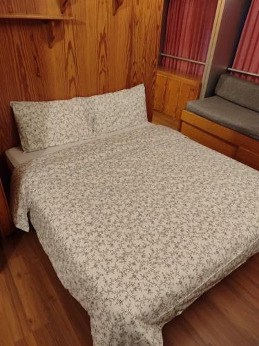a small bed in a room with wood paneling at Residence Sole Alto Marillleva 1400 - vista bosco in Marilleva