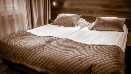 a large bed with two pillows on top of it at Hotell Nivå in Boden