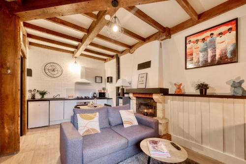 un salon avec un canapé bleu et une cuisine dans l'établissement Le cocooning, à Lannion