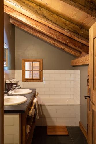 une salle de bain avec deux lavabos et une baignoire dans l'établissement Pags Haut, à Châtel