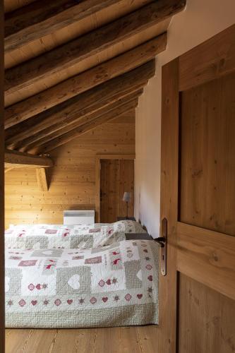 une chambre avec un lit et un plafond en bois dans l'établissement Pags Haut, à Châtel
