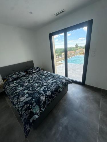 une chambre avec un lit et une grande fenêtre dans l'établissement Magnifique maison de village avec piscine chauffée et jacuzzi, à Montfrin