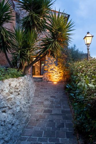 a stone pathway leading to a house with palm trees at Abruzzo Tower in Montorio al Vomano
