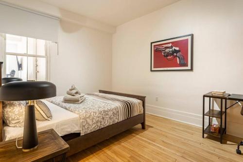 a bedroom with a bed with a chair and a table at Charm & Luxury Vacation Headquarters to Downtown! in Montréal