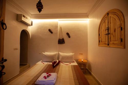a small room with a bed with white pillows at riad dar wlidati in Marrakech