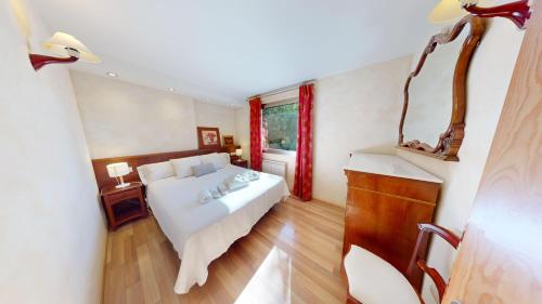 a bedroom with a white bed and a window at Apartaments Boutique la Torreta del Llac in Puigcerdà