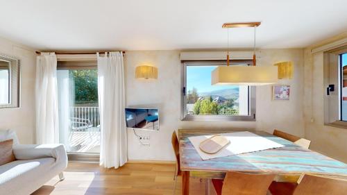 a dining room with a table and a couch at Apartaments Boutique la Torreta del Llac in Puigcerdà