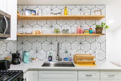 a kitchen with a sink and a tile wall at Stylish Casita min from the beach ! in San Juan Capistrano