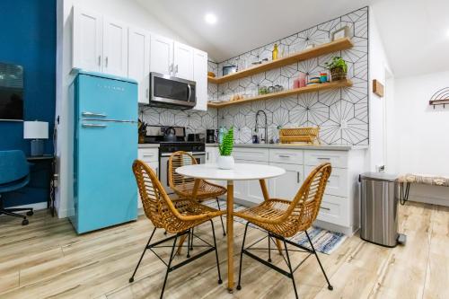 a kitchen with a table and chairs and a blue refrigerator at Stylish Casita min from the beach ! in San Juan Capistrano