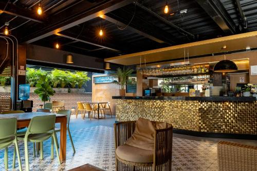 a restaurant with a bar and tables and chairs at Hotel Foresto 365 in Cali