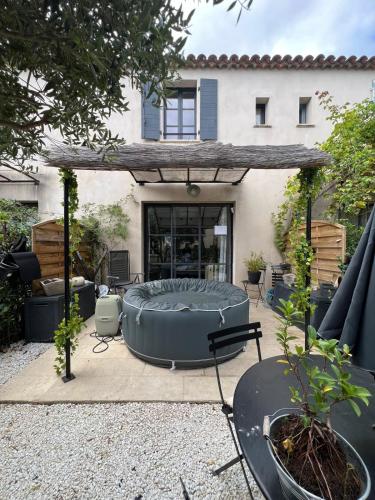 une terrasse avec un grand lit rond en face d'une maison dans l'établissement Maison T3 avec spa, à Saint-Laurent-de-la-Cabrerisse