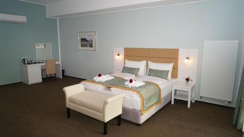 ein Hotelzimmer mit einem großen Bett und einem Stuhl in der Unterkunft Hotel Class in Hamburg