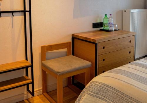 a bedroom with a bed and a dresser with a chair at Котеджі Грань in Bukovel