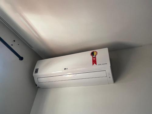 a white air conditioner in a corner of a room at Quartos Quintal Bueno! Com ar, tv e internet no melhor bairro de Goiânia! Perto do Goiânia Shopping, Parque Areião Hospital Premium Mater Dei OVG Vaca Brava Marista Campo do Goiás! in Goiânia