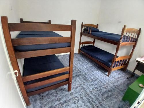 two bunk beds sitting in a room with at Hostel 5C - Itanhaém in Itanhaém
