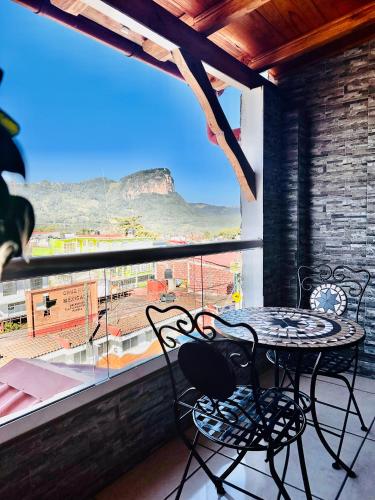 a table and chairs on a balcony with a view at Hotel & Suites Cerro Roj0 in Tlatlauquitepec