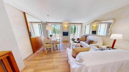 a bedroom with a bed and a living room at Apartaments Boutique la Torreta del Llac in Puigcerdà