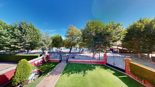 a park with a green yard with trees and a fence at Apartaments Boutique la Torreta del Llac in Puigcerdà