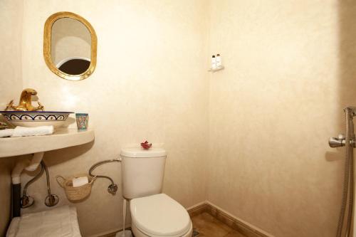 a bathroom with a toilet and a sink and a mirror at riad dar wlidati in Marrakech