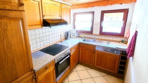 a kitchen with wooden cabinets and a stove top oven at Ferienwohnung Wehra in Todtmoos in Todtmoos