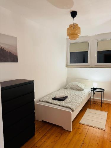 a bedroom with a bed with a black dresser and windows at Familien Ferienhaus in der Vulkaneifel -Mechthild- in Ettringen
