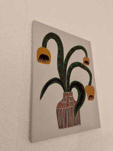 a painting of a plant in a vase on a wall at Familien Ferienhaus in der Vulkaneifel -Mechthild- in Ettringen