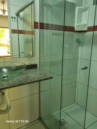 a bathroom with a glass shower and a sink at O Pharol Hostel e Pousada in Itacaré