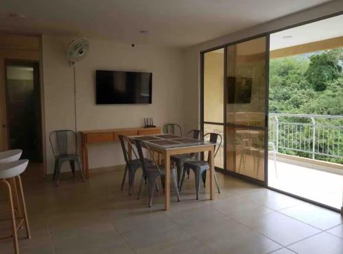 a dining room with a table and chairs and a television at Casa-Ámbar in Villeta