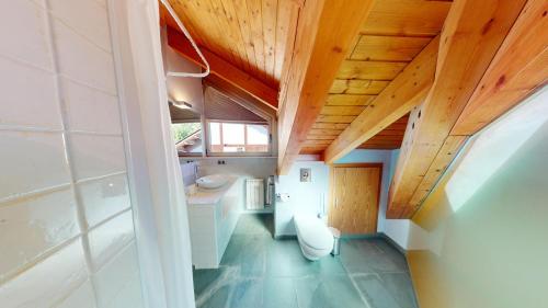 an attic room with wooden ceilings and a bathroom at Apartaments Boutique la Torreta del Llac in Puigcerdà