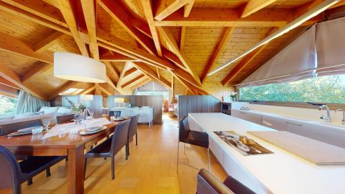 a kitchen and dining room with a wooden ceiling at Apartaments Boutique la Torreta del Llac in Puigcerdà
